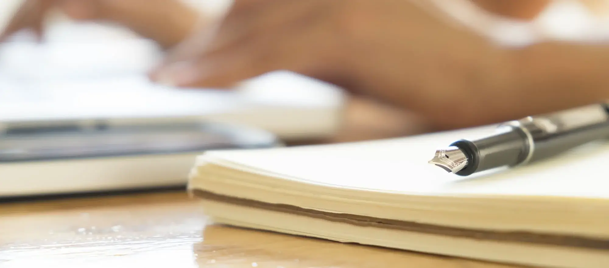stylo et papier sur un bureau en bois | © Freepik